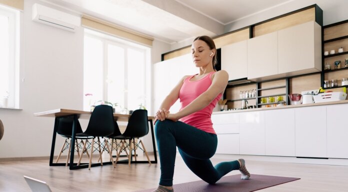 Tips to Organizing Your Home Workout Attractive woman practicing yoga at home using online training instructions