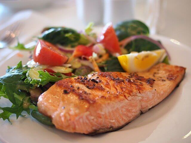 Salmon and a salad served on a white plate