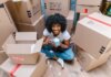 Mistakes People Make When Moving During The Pandemic A girl surrounded by moving boxes