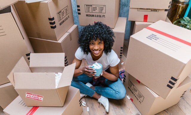 Mistakes People Make When Moving During The Pandemic A girl surrounded by moving boxes