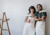 How To Plan A DIY House Remodel? A couple posing with paint rollers.