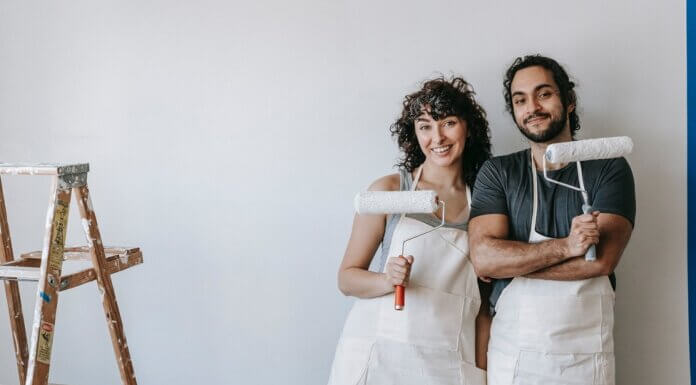 How To Plan A DIY House Remodel? A couple posing with paint rollers.